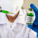 Scientists wearing masks and gloves Holding a syringe with a vac